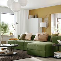 a living room filled with lots of furniture and pillows on top of a green couch