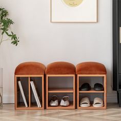 three wooden shelves with shoes on them in front of a white wall