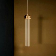 a light fixture hanging from the ceiling in a room with brown walls and flooring