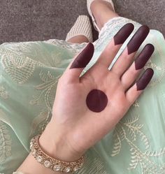 a woman's hand with dark colored nails and ring fingernails on it