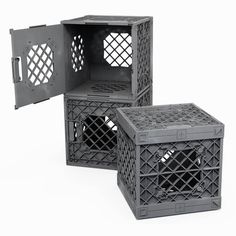 two black plastic crates sitting next to each other on top of a white surface with holes in them