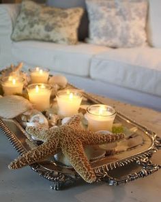 a tray filled with candles sitting on top of a table next to a white couch