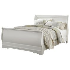 a white bed with pillows and blankets on it