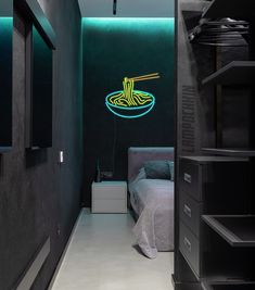 a bed room with a neatly made bed and a neon sign on the wall