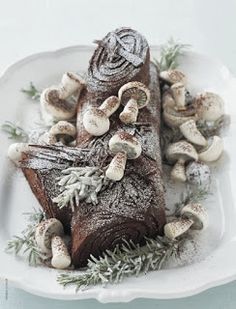 a white plate topped with a piece of cake covered in powdered sugar and mushrooms