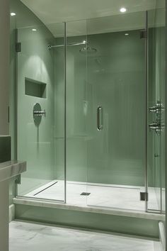 Serene sage green and blush bathroom featuring glass shower doors and chrome fixtures