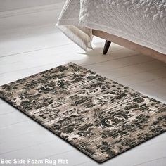 a bed sitting next to a rug on top of a wooden floor