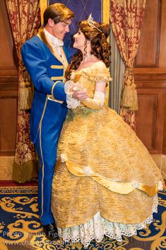 a man and woman dressed as disney characters in formal dress standing next to each other