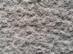 closeup of the texture of a granite surface with gray and white colors, as well as black dots