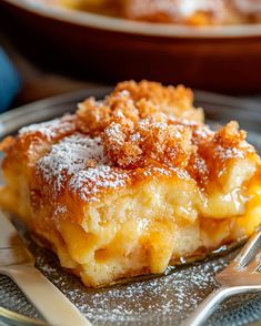 a close up of a piece of cake on a plate with a fork and bowl in the background