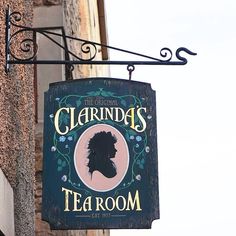 a sign hanging from the side of a building that says, the original claridas tea room