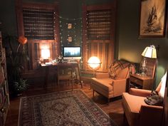 a living room filled with furniture next to a window covered in blinds and lights at night