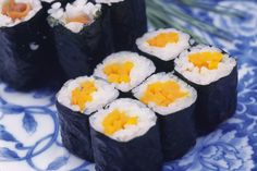 sushi rolls are arranged on a blue and white plate