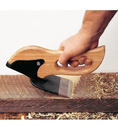 a person using a wood plane to sharpen a piece of wood with a knife