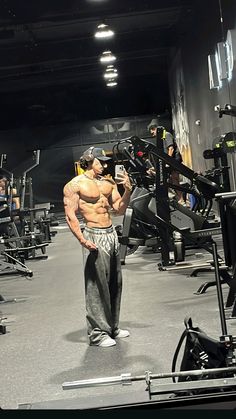 a man standing in a gym holding a camera