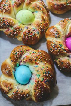 several buns with colorful sprinkles and an easter egg in the middle