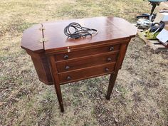 an old wooden dresser sitting on top of a grass covered field next to a bicycle