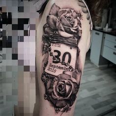 a black and white photo of a woman's arm with a rose tattoo on it