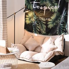 a living room filled with furniture and a large tapestry hanging on the wall above it