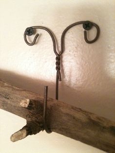 a pair of hooks are attached to a wooden beam in the corner of a room