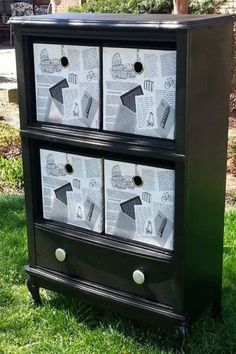 a black and white dresser with newspaper drawers on it's sides in the grass