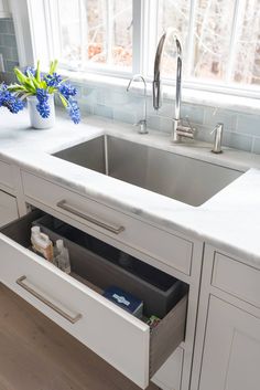 a kitchen sink with an instagram on the left side and blue flowers in the middle