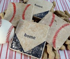 four baseball coasters sitting on top of a table next to nuts and a ball