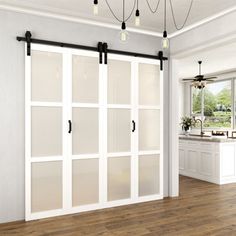 an open kitchen with white cabinets and sliding glass doors that lead to the dining room