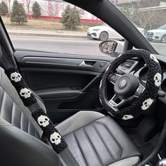 the interior of a car is decorated with skulls and crocheted steering wheel covers