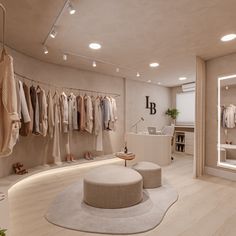 the inside of a clothing store with lots of clothes hanging on racks and stools