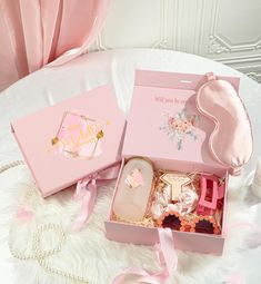 the pink box is filled with personal care items and sits on a white furnishing