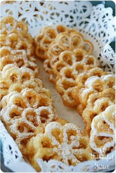 some kind of food that is in a white bowl on a table with doily