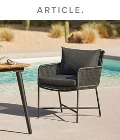 an outdoor table and chair next to a pool with the words article written below it