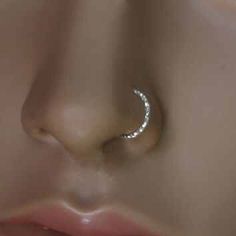 a nose piercing with a crescent design on it