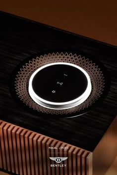 an electronic device is sitting on top of a wooden box that has a circular light in the middle