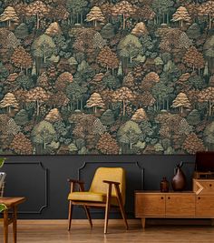 a living room with a chair and wallpaper that has trees on the wall behind it