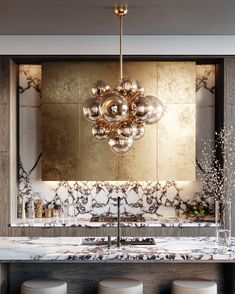 a kitchen with marble counter tops and stools in front of a large chandelier