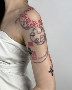 a woman with a tattoo on her arm is wearing a white dress and red flowers