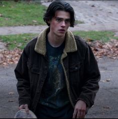 a young man holding a skateboard in his hands