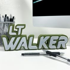 an office desk with pens, markers and a desktop computer on it that says gt walker