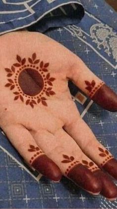 a person's hand with henna on it and an orange ring in the middle