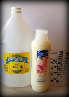 a bottle of milk and a gallon of vinegar sitting on a counter next to each other