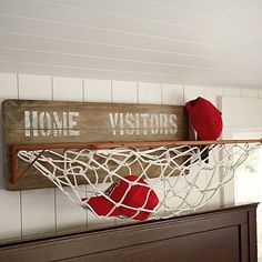 a wooden sign that says home visitors hangs on a wall above a hammock