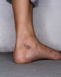 a person's foot with a small tattoo on the side of their left leg