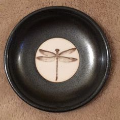 a black and white plate with a dragonfly on it