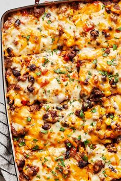 a casserole dish with cheese, black beans and other toppings on top