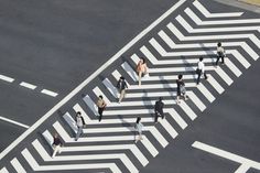 an aerial view of people walking across a crosswalk