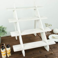 a pair of yellow shoes sitting on top of a wooden shelf next to a potted plant