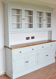 an empty kitchen with white cabinets and wood flooring on the sideboard, along with wooden floors