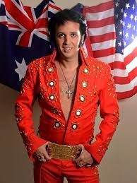 a man dressed in red and gold with an american flag on the wall behind him